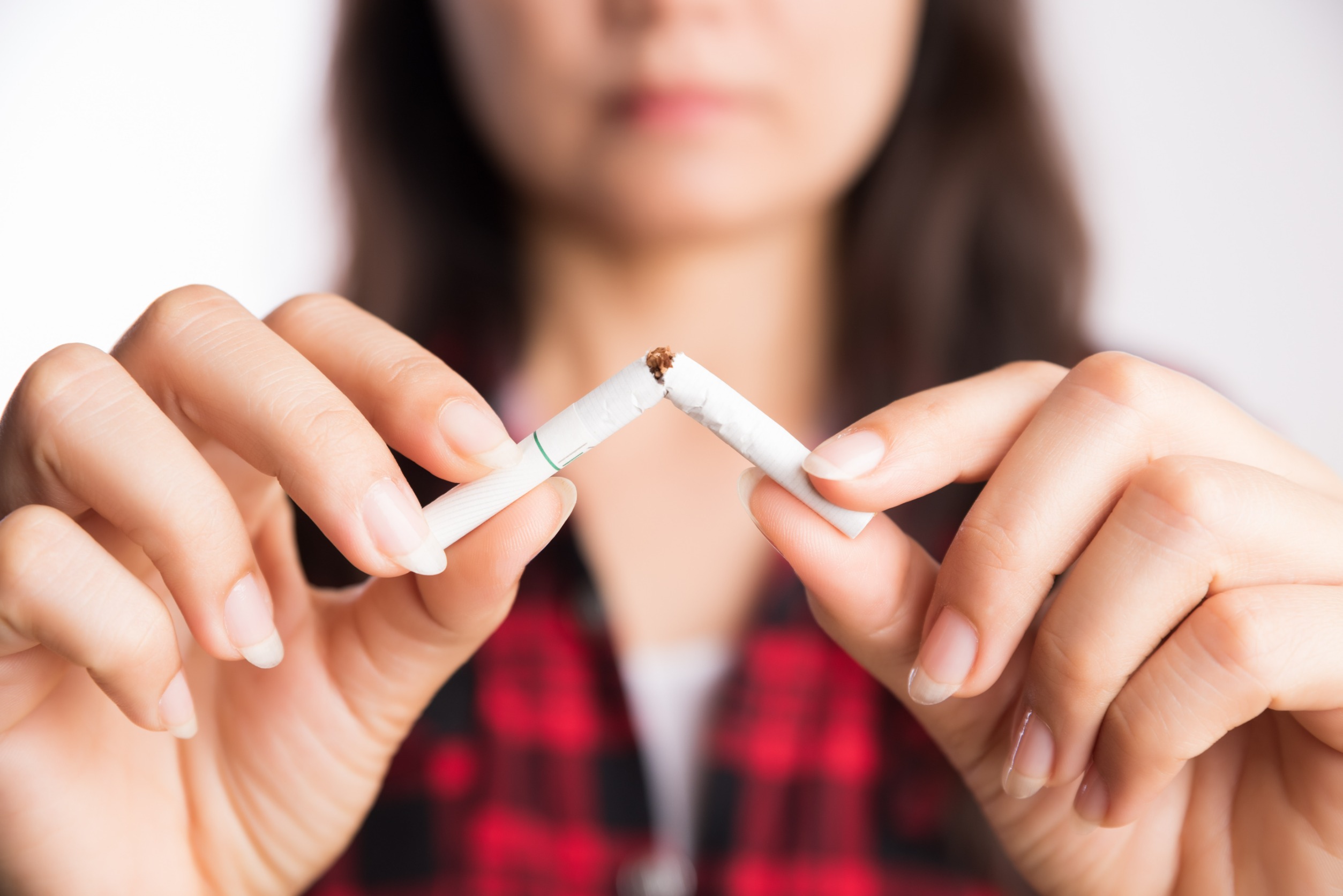 Woman breaking cigarette in half