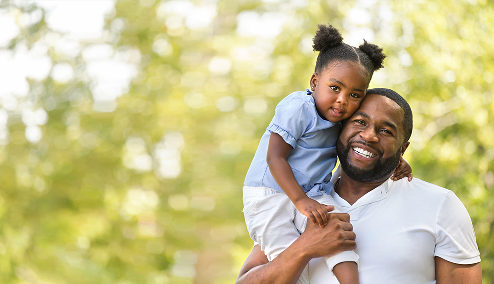 African American father hugging and holding his little girl.