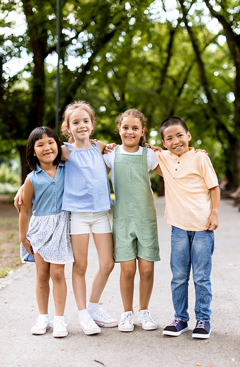 Group of cute asian and caucasian kids having fun in the park