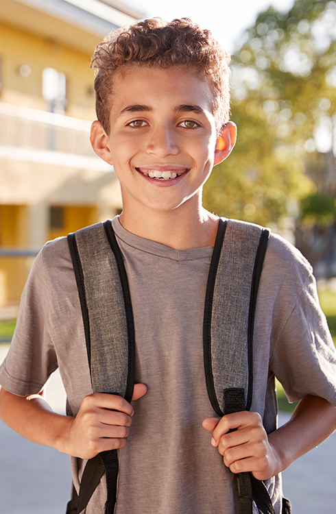 Portrait of smiling elementary school boy with his backpack